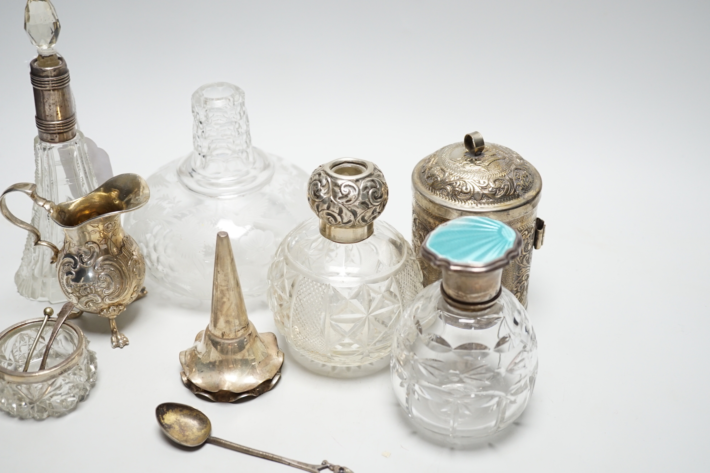 Sundry items including a German 800 white metal cream jug, three mounted glass scent bottles including silver and enamel, Indian white metal cannister, etched glass decanter, etc.